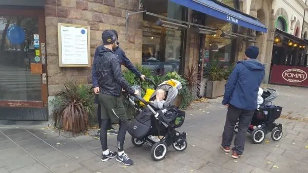 스톡홀름 거리 곳곳에서 유아차를 끄는라테파파 사진-3명의 아빠들이 유모차를 두고 얘기 중인 사진